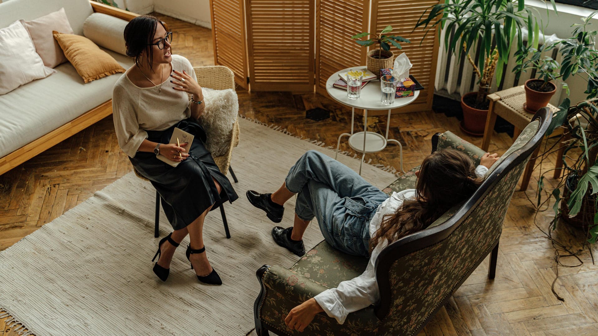 why people overshare with ai -- woman in white long-sleeve shirt sitting on brown wooden armchair talking to another woman on a lounge chair