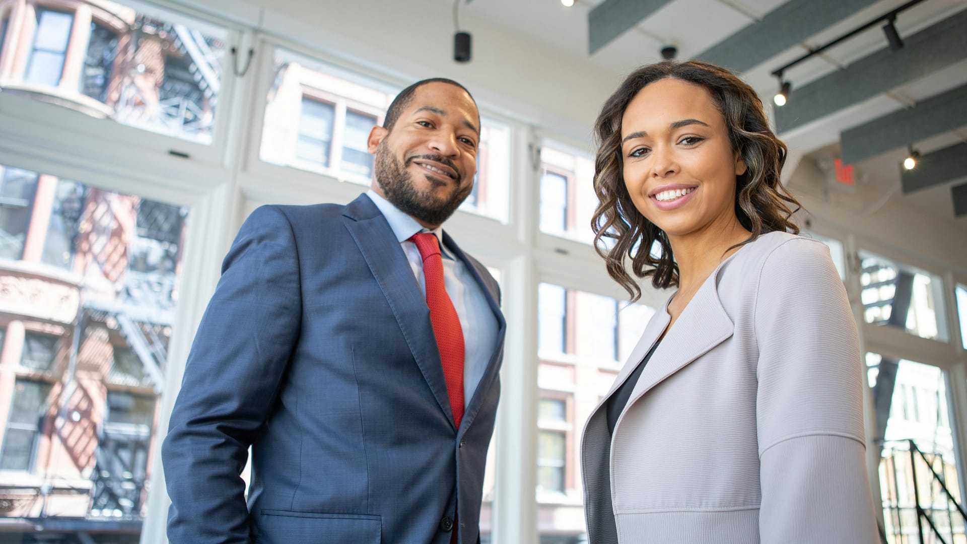 teach ai fluency empower without losing control -- a photo of a man and a woman smiling inside a building
